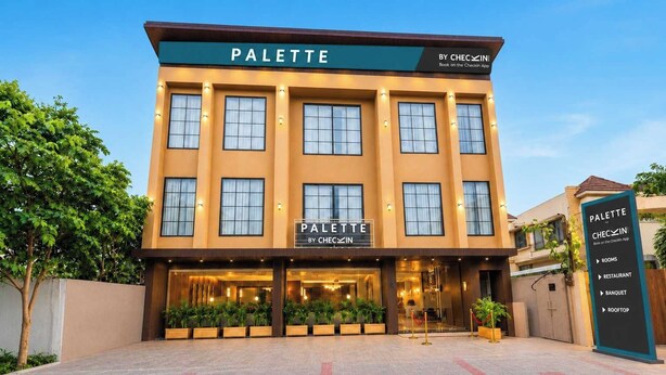Un hôtel appelé « PALETTE BY CHECIN », dont l’enseigne indique la présence de différents services, tels que des chambres, un restaurant, une salle de réception et un toit-terrasse.