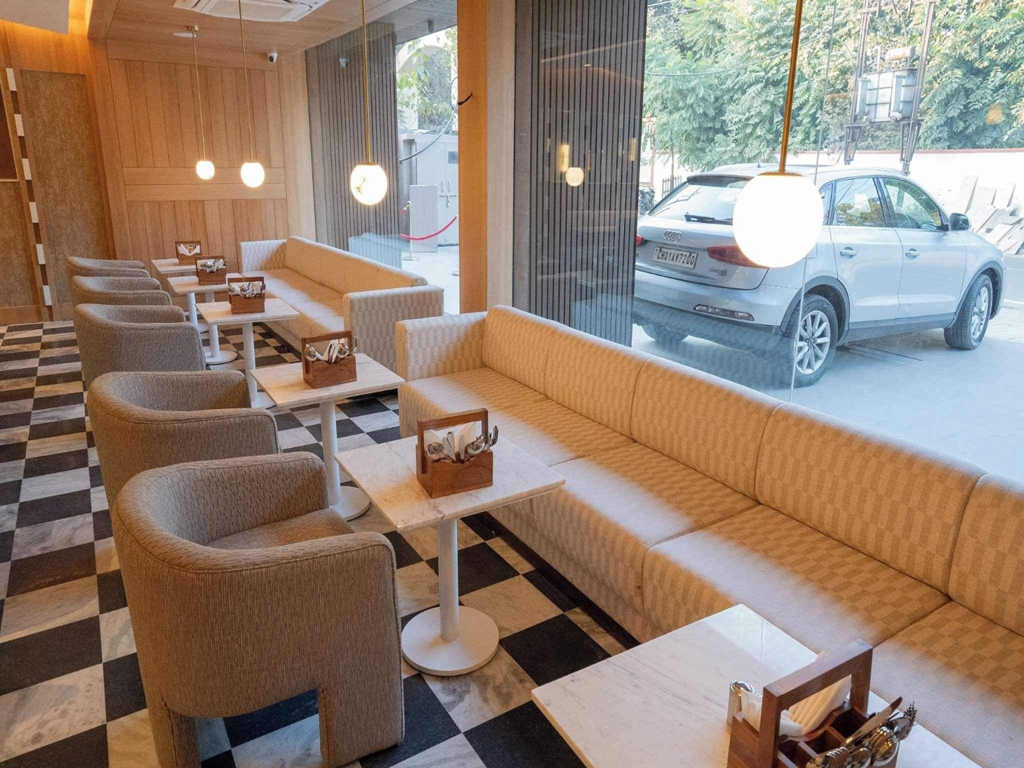 Un restaurante con suelo a cuadros, asientos acolchados y mesas con sujetaporta servilletas.
