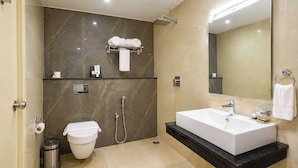 A modern bathroom with a white sink, a toilet, a shower, and a large mirror. - Palette Hotel by CheckIn, Visakhapatnam (Visakhapatnam)