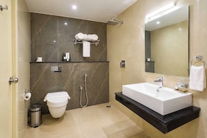 A modern bathroom with a white sink, a toilet, a shower, and a large mirror. - Palette Hotel by CheckIn, Visakhapatnam (Visakhapatnam)