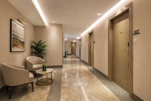 A hotel corridor with a reception area, seating, and doors numbered 107. - Palette Hotel by CheckIn, Visakhapatnam (Visakhapatnam)