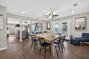 A spacious living area with a wooden dining table, black chairs, and a blue sofa. - Lake Degray Golf-Course and Lake Retreat/Covered Patio 4 Bedrooms 3 Full Bath (Bismarck)