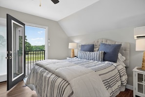 A bedroom with a large bed, a balcony door, and a view of a green landscape. - Lake Degray Golf-Course and Lake Retreat/Covered Patio 4 Bedrooms 3 Full Bath (Bismarck)