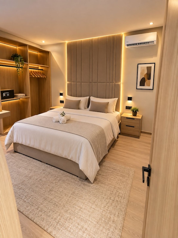 Quarto moderno com uma cama grande, mesas de cabeceira, guarda-roupa e ar condicionado.