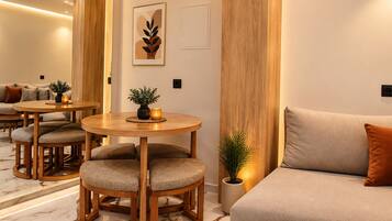 Un intérieur moderne avec un canapé, une table ronde en bois et une petite plante en pot.