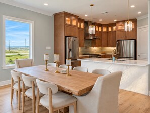A modern kitchen with a large island, stainless steel appliances, and a view of the outdoors. - Beachfront, Private Elevator, Hot Tub, Sleeps 24 (Freeport)