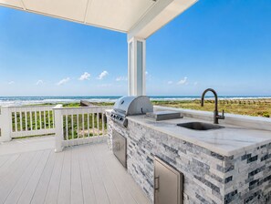 A balcony with a view of the ocean, a grill, and a sink. - Beachfront, Private Elevator, Hot Tub, Sleeps 24 (Freeport)