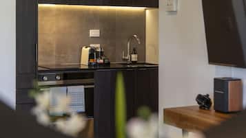 Eine moderne Küche mit Einbauofen, Kaffeemaschine und Spüle.