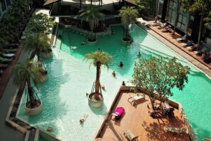 A rooftop pool with multiple levels, surrounded by palm trees and lounge chairs. - Kamala - Sea View (Kathu District)