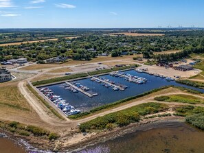 An aerial view of a marina with multiple docks and boats, surrounded by greenery and residential buildings. - "Boris" - 50m to the fjord by Interhome (Tarm)