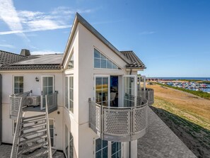 A modern two-story building with a balcony, a staircase, and a view of the beach and boats. - "Boris" - 50m to the fjord by Interhome (Tarm)
