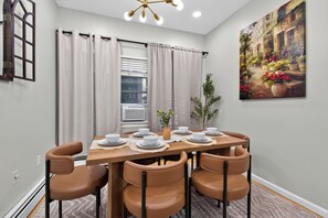 A dining area with a wooden table set for six, surrounded by six brown chairs. - Classic 3 bedroom Hoboken Retreat  Private Backyard (Hoboken)