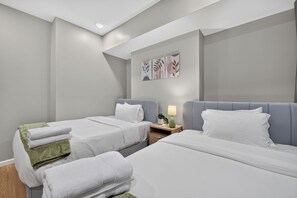 Ein Hotelzimmer mit zwei Betten, einem Nachttisch mit Lampe und Wandbildern.
