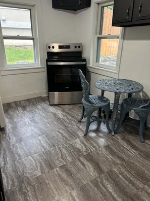 A kitchen with a built-in oven and a dining table with chairs.