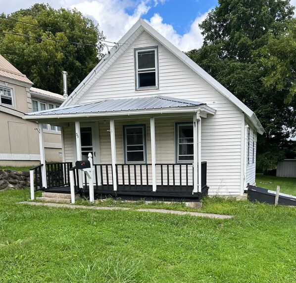 A single-story house with a front porch, a mailbox, and a small front yard.