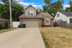 A two-story residential house with a garage, a front yard, and a wooden fence. - Marvel-ous 4 BD/2.5 BA Home in Royal Oak (Royal Oak)