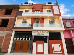 Un edificio de dos pisos con un letrero que dice 'Mangal Bhawan Home Stay'.