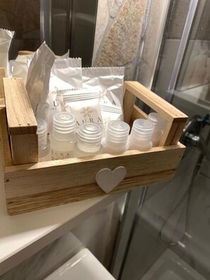 Une caisse en bois contenant des bouteilles et des sachets étiquetés « AURA », posée sur une étagère.