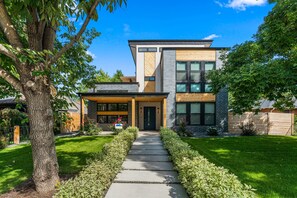 A modern two-story house with a visible front entrance, a covered porch, and a well-maintained lawn. - 2 bed, 1 bath Basement Apt. with W/D in Custom Home and 1 Garage Parking Space (Denver)