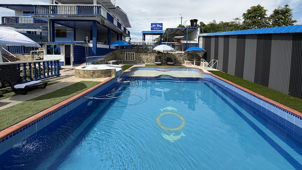 A swimming pool with a hot tub, lounge chairs, and a covered outdoor seating area. - Artehotel del Quindío  (Filandia)