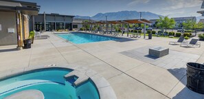 Ein Poolbereich mit Liegestühlen und einem Whirlpool.