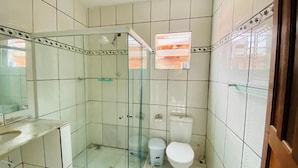 Ein Badezimmer mit Duschkabine, Toilette und Waschbecken.