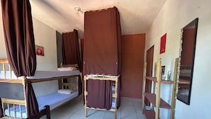 Ein Schlafsaalzimmer mit Etagenbetten, einem Spiegel und einem Ablagebereich für Toilettenartikel.