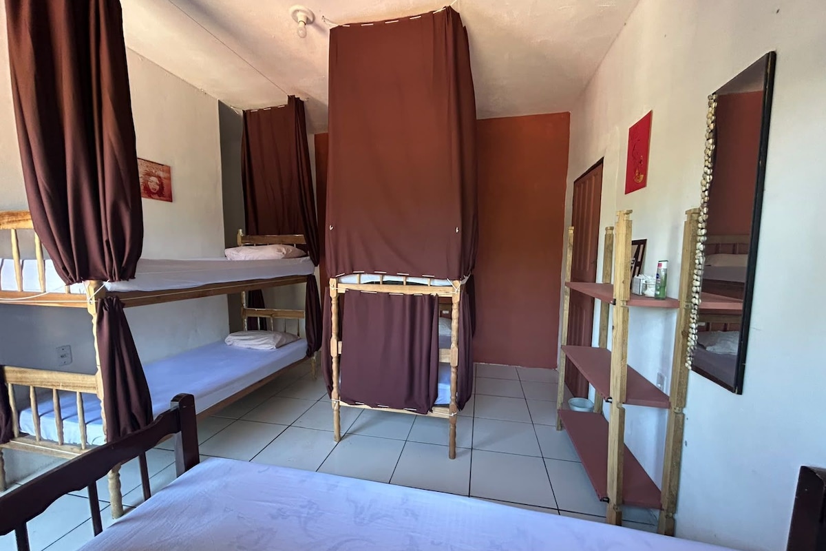 Una camera del dormitorio con letti a castello, uno specchio e uno scaffale con articoli da toilette.