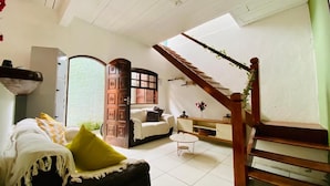 Ein gemütliches Wohnzimmer mit einer Couch, einem Couchtisch und einer Treppe.
