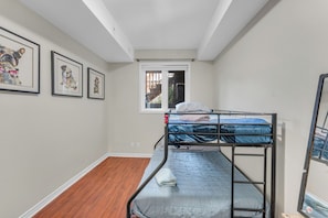 Una habitación con literas, una ventana y cuadros en la pared.