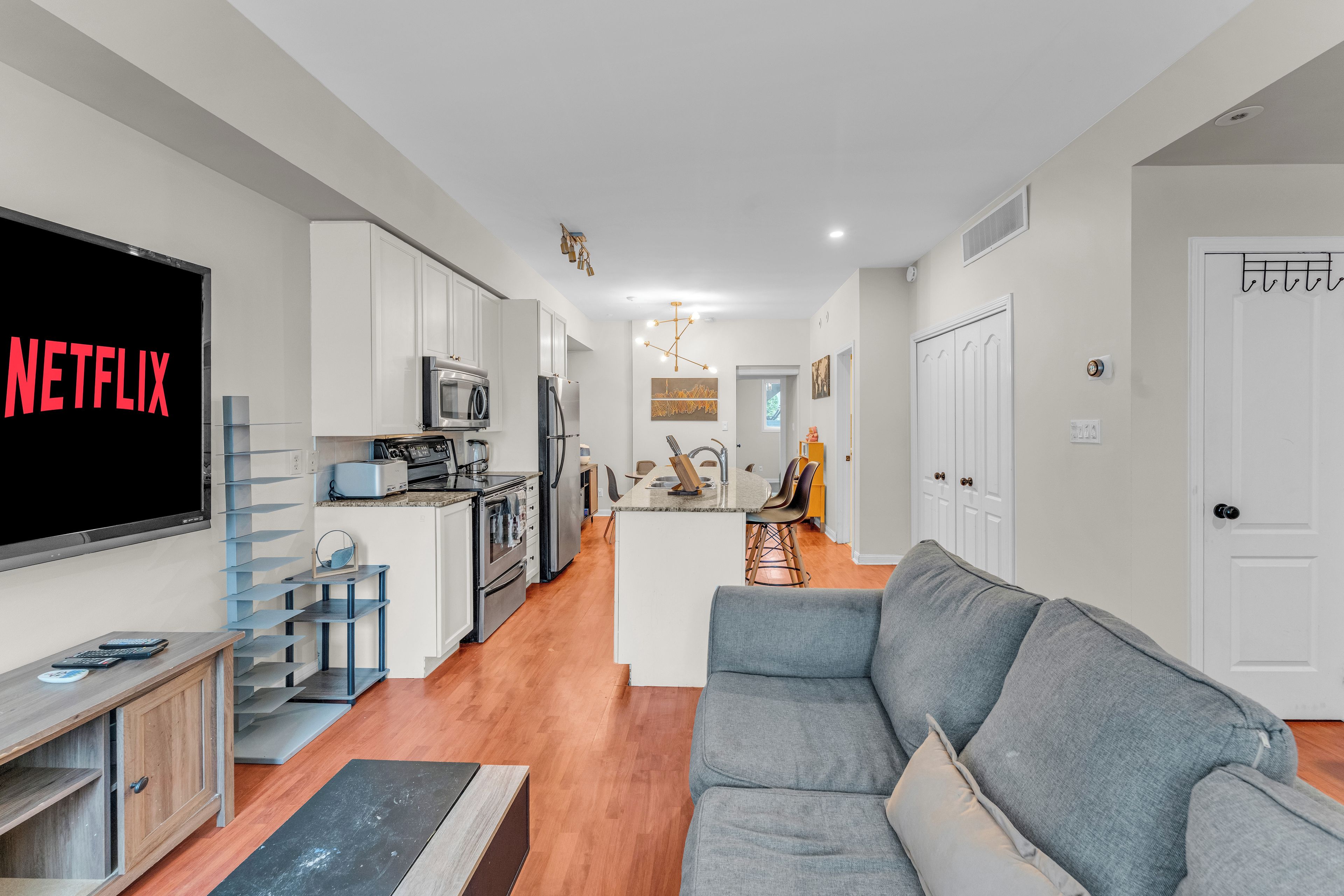 A modern kitchen with white cabinets, a built-in oven, and a microwave.