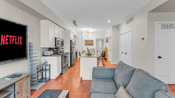 A modern kitchen with white cabinets, a built-in oven, and a microwave.