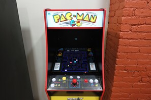 A Pac-Man arcade machine with a maze game, score display, and control buttons. - Hoboken Fun House Walk to PATH Sleeps 7 (Hoboken)