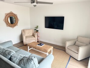 Ett vardagsrum med en soffa, en fåtölj och ett soffbord.