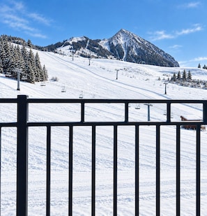 Ein mit Schnee bedeckter Skipisten mit Seilbahnen und einem Berg im Hintergrund.