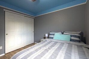 Une chambre à coucher avec un lit, une table de chevet et une porte fermée.