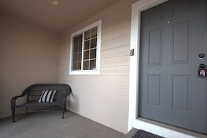 A front door with a mailbox, a bench, and a window. - Spacious 4BR Home - Sleeps 8 - Home Theater, Fenced Yard & BBQ (Thornton)