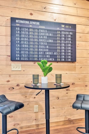A wooden wall with a digital departure board displaying flight information. - 8BR • 25 Beds • Indoor Pool • Tiki Bar • Hot Tub (Sevierville)