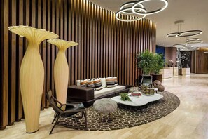 A modern interior with a sofa, coffee table, and tall vases. - Unbeatable Luxury Penthouse Combo with Ocean Views (Hollywood)