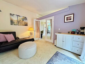A living room with a sofa, ottoman, and a coffee station. - Lavender Suite on the Dungeness River (Sequim)