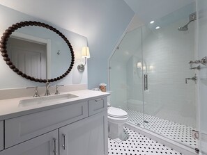 A bathroom with a glass-enclosed shower, a white toilet, and a vanity with a mirror and two sinks. - Cozy 3-bedroom house in fabulous Bozeman with AC (Bozeman)