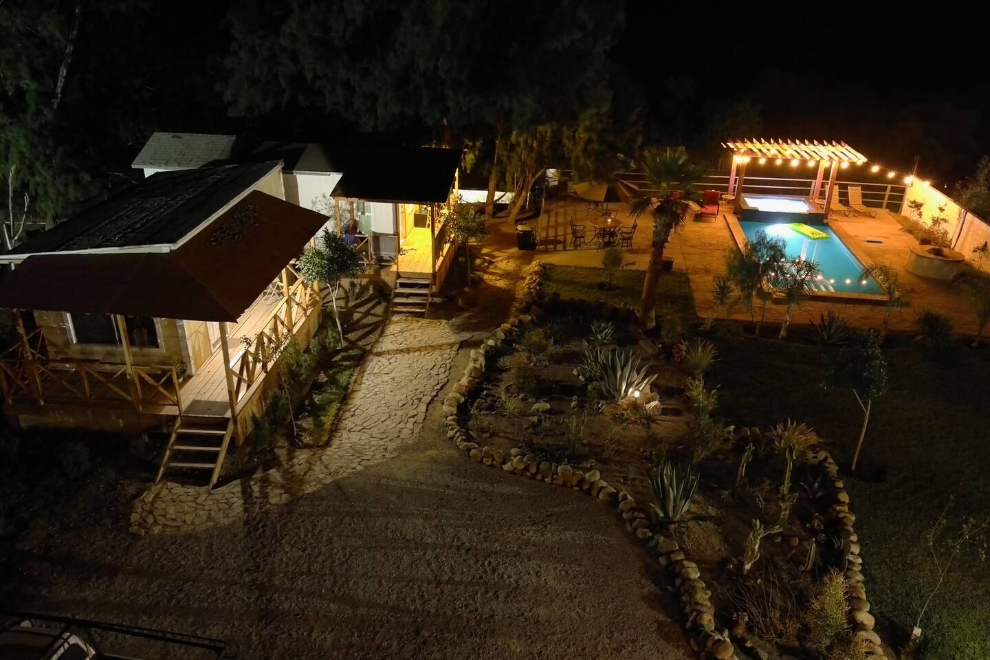 Un espace extérieur bien éclairé, doté d’une piscine, d’un coin salon abrité et d’une terrasse en bois.
