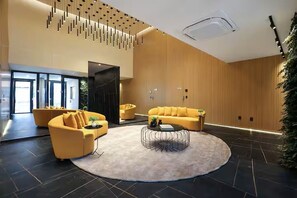 A modern lobby with two sofas, a round coffee table, and a large window. - Premium Apartment in Setor Bueno | Full-Service Condominium with Heated Pools (Goiânia)