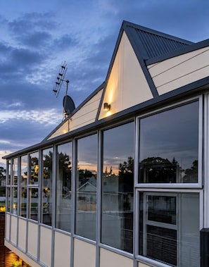 A modern building with large windows and a sloped roof. - Love It on Lemon | Stay Central | Explore More! (New Plymouth)