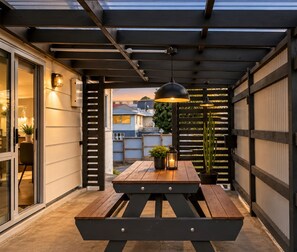Covered patio with ambient lighting and cozy outdoor dining setup - Love It on Lemon | Stay Central | Explore More! (New Plymouth)