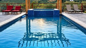 A swimming pool with a pergola overhead, surrounded by lounge chairs, set against a mountainous backdrop. - Quinta Aurora - Relaxing Wine Country Casa w/Pool (San Marco)