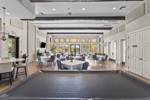 A spacious indoor area with multiple tables and chairs, a pool table, and a large window providing natural light. - 3BR/3BA · Private Heated Pool · Gated Resort · Near Venice & Gulf Beaches (Nokomis)