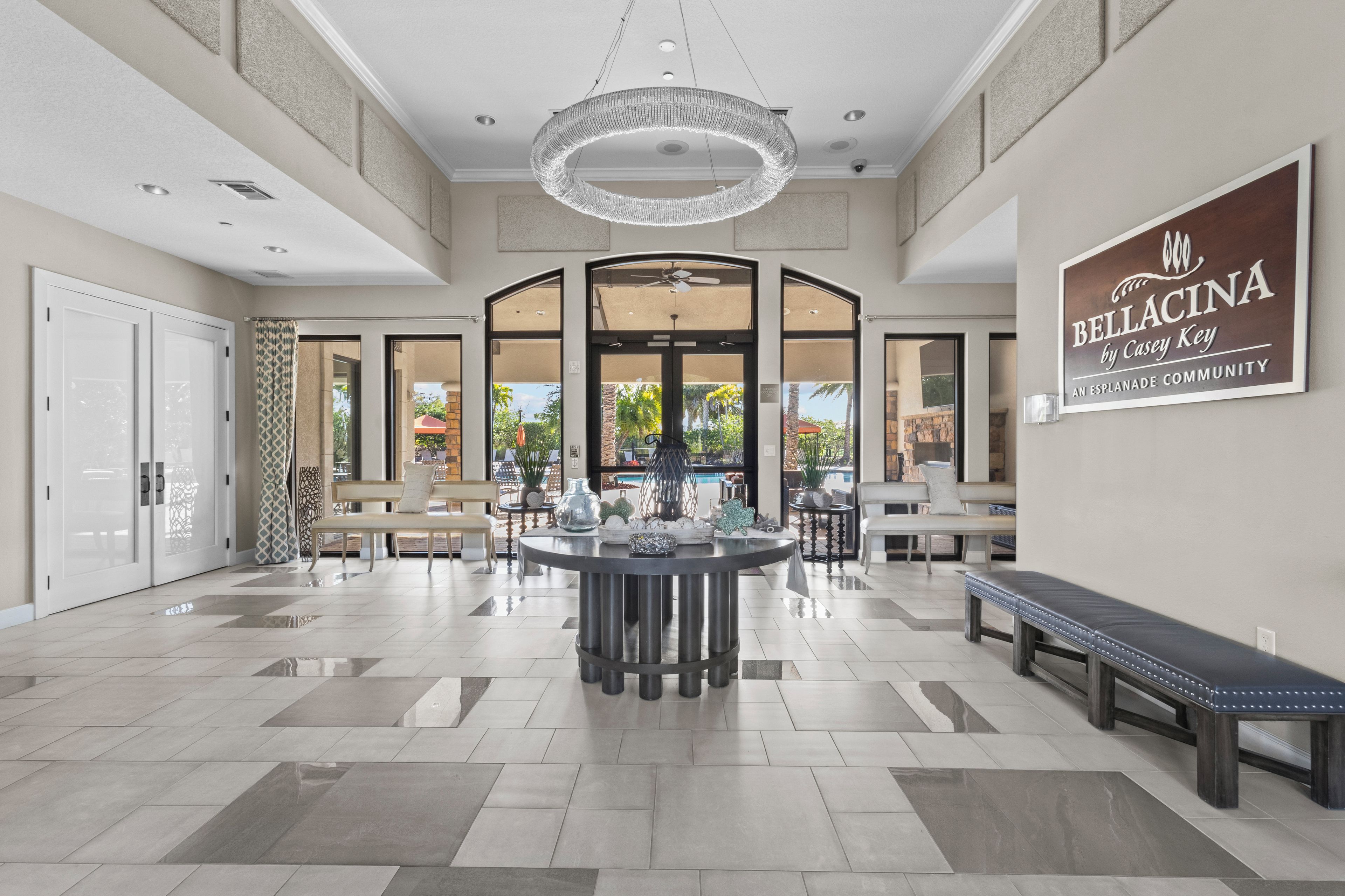 A spacious lobby with a central round table, seating arrangements, and a chandelier.
