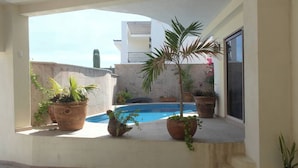 A pool area with potted plants and a view of a building in the background. - Tranquil Cabo Villa w/ Private Pool, Grill & Patio (Cabo San Lucas)