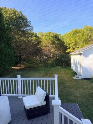 A deck with a single black lounge chair and a white railing. - Quaint 2-bedroom bungalow, close to the ocean in charming Thomaston (Thomaston)